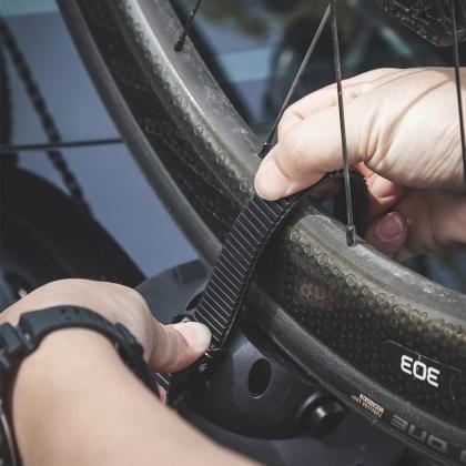  A person securing a bike wheel on the TreeFrog Pro 2 Bike Rack.
