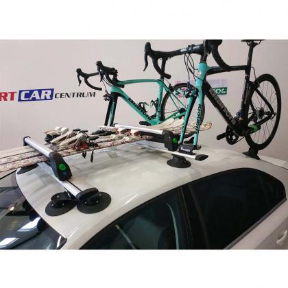 A car with two bikes secured on top, featuring sleek black Treefrog roof rack crossbars.