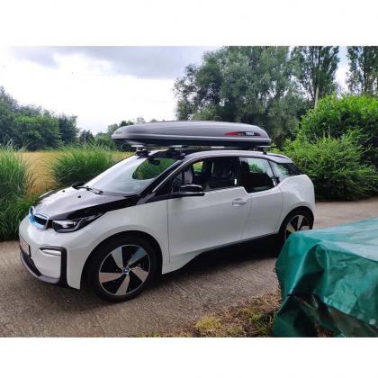 A stylish BMW i3 equipped with a black Treefrog roof rack crossbar, perfect for carrying gear on the go.