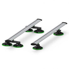 Two green and black car racks with black wheels, featuring TREEFROG ROOF RACK CROSSBARS in silver
