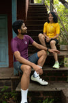 a man and women wearing purple and yellow cycling jerseys talking with each other 