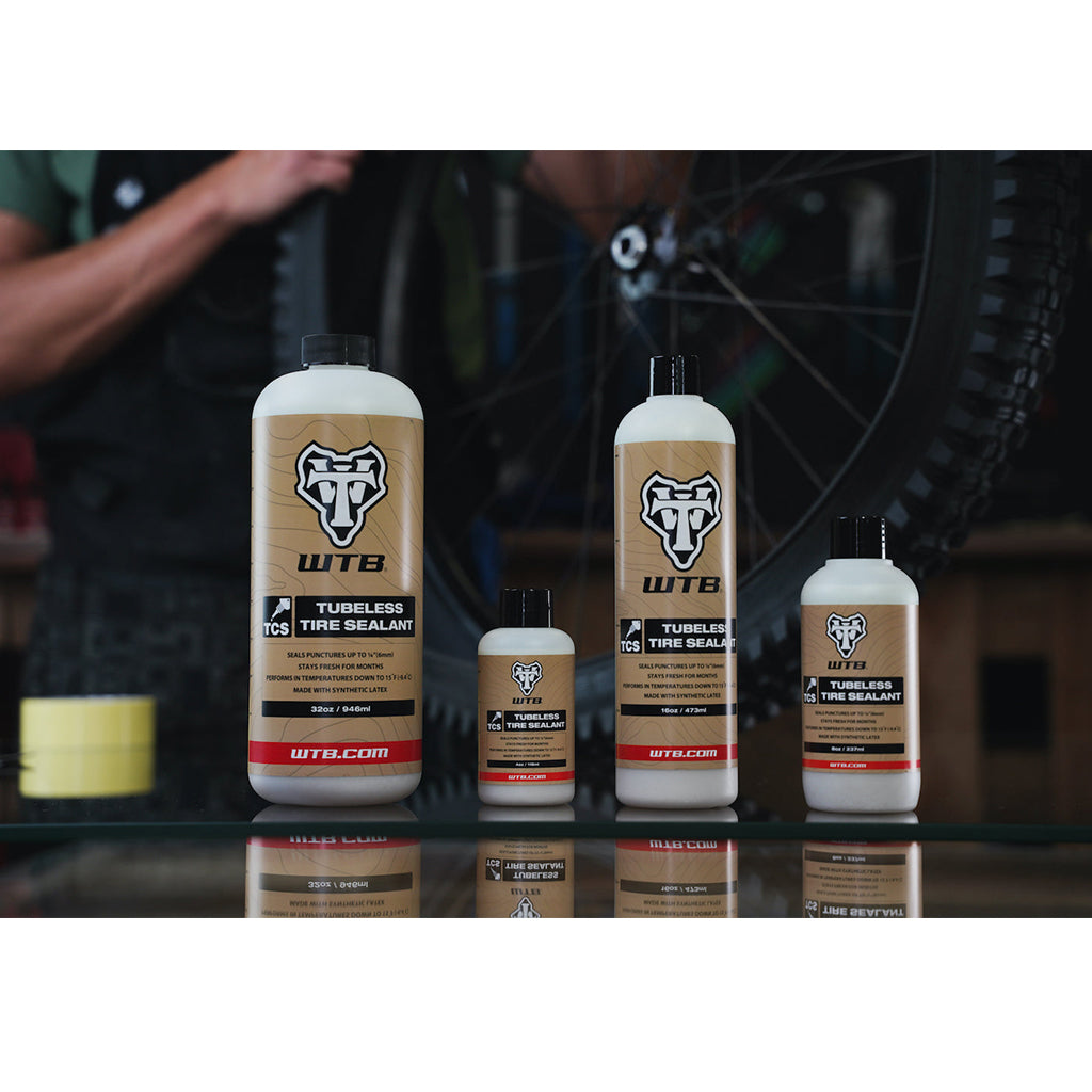 WTB TCS sealant being poured into a bicycle tire, demonstrating its use in a tubeless setup.

