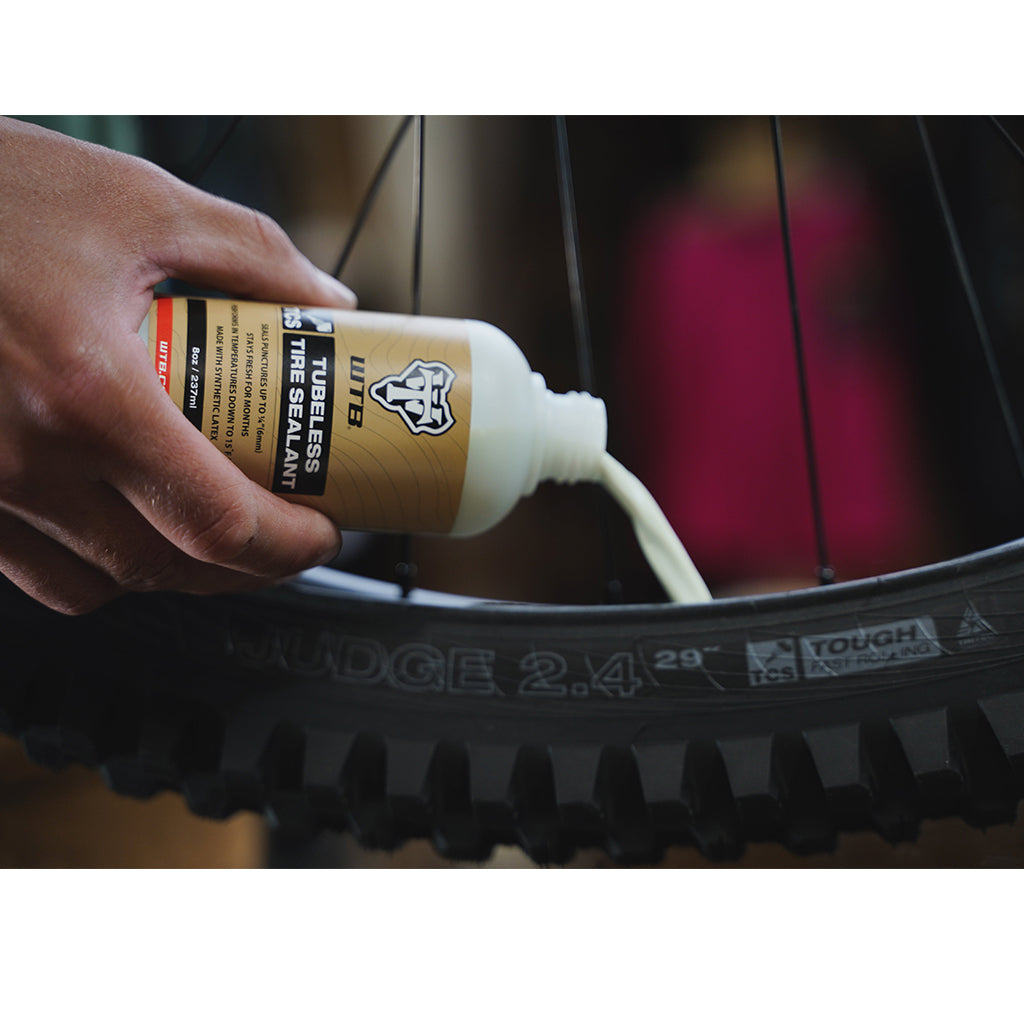 Close-up of the WTB TCS Tire Sealant bottle, showing its compact size for easy storage and use on the go.


