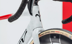 Close-up image of a Wilier Filante SLR aero carbon bike, highlighting its glossy red and white stripes on a graphite white frameset.