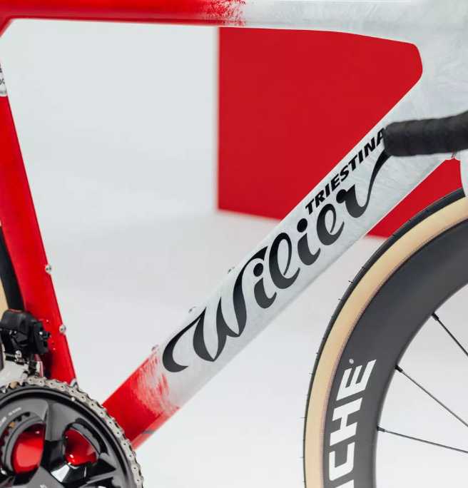 A red and white aerodynamic Wilier Filante SLR bicycle with "wilier triestina" displayed on its glossy carbon frame