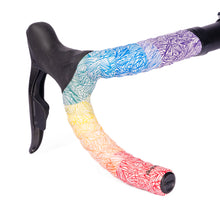 GUEE Attitude Fade Rainbow bar tape, showcasing a vibrant gradient of colors on a bicycle handlebar.