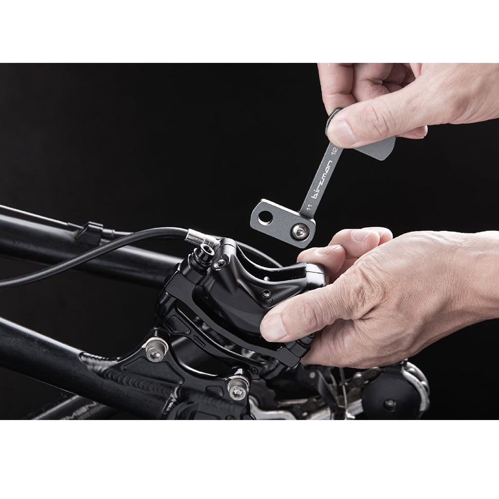 Birzman Piston Release Tool inserted into a four-piston disc brake caliper.