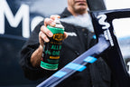 Mechanic applying Blub All in One spray lubricant to a professional road bike frame.