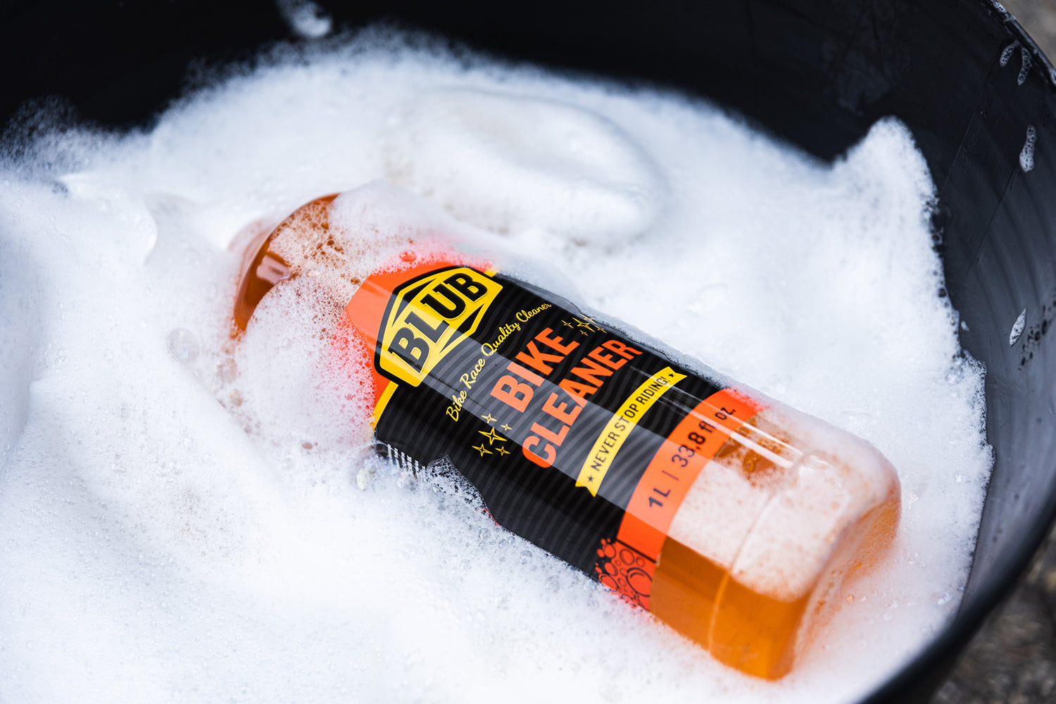 Blub Bike Cleaner 1L bottle lying in a foam-filled bucket.