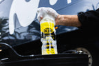 Hand spraying Blub Bio Degreaser foam from the 1L bottle onto a bicycle drivetrain.