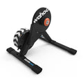 Wahoo KICKR CORE 2 smart trainer with Zwift Cog and Click, three-quarter front view showing the Wahoo-branded flywheel and compact frame
