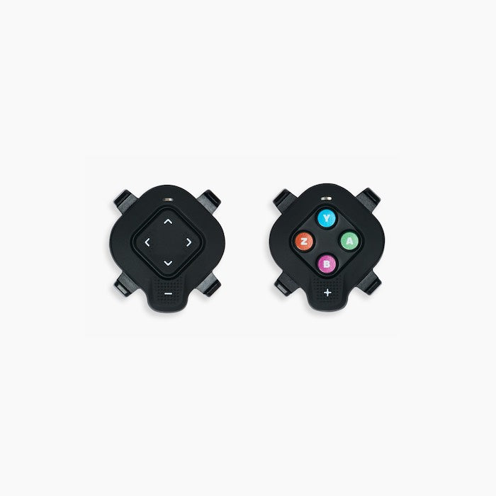 Pair of Zwift Click controllers for the Wahoo KICKR CORE 2 showing the steering D-pad and programmable action buttons