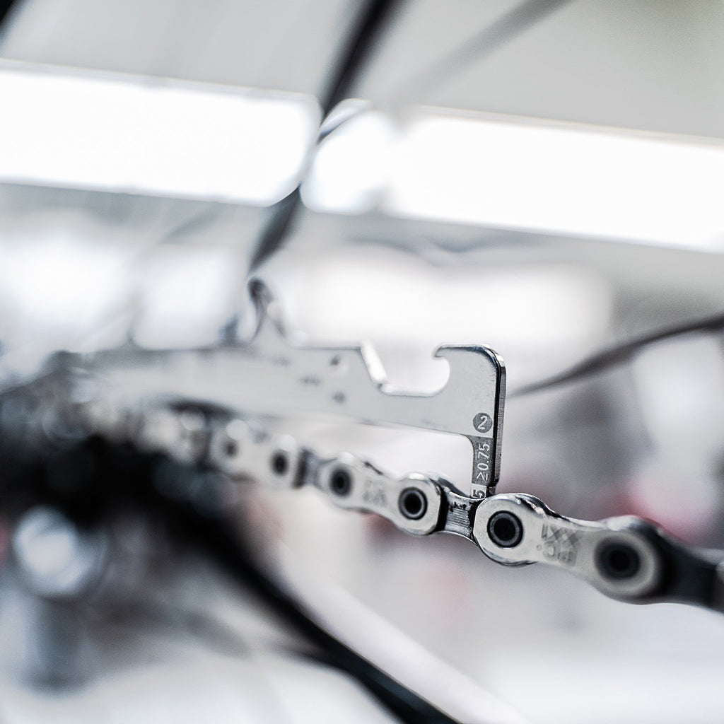 Chain wear checker tool with integrated chain hook

