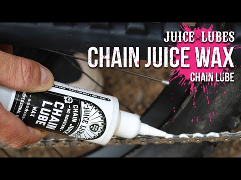 Juice Lubes Chain Juice Wax (130ml), shown being applied to a bike chain, indicating its use for a clean and efficient drivetrain.

