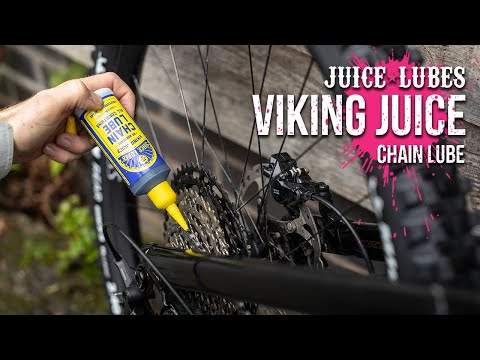 Juice Lubes Viking Juice - All Condition Chain Oil (130ml), shown being applied to a bike chain, indicating its adaptability for year-round riding.