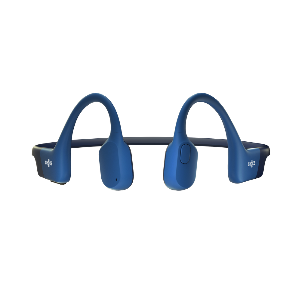 Runner wearing Shokz OpenRun blue bone conduction headphones outdoors