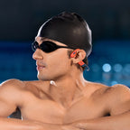 Swimmer wearing Shokz OpenSwim Pro red waterproof headphones in open water