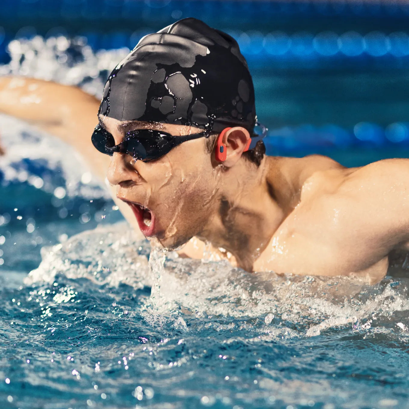 Swimmer wearing Shokz OpenSwim Pro waterproof headphones in the pool
