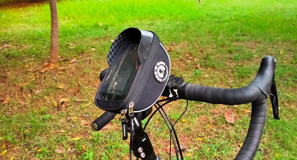 Close-up of the handlebar mobile bag showing the glare-reducing visor and Velcro straps.
