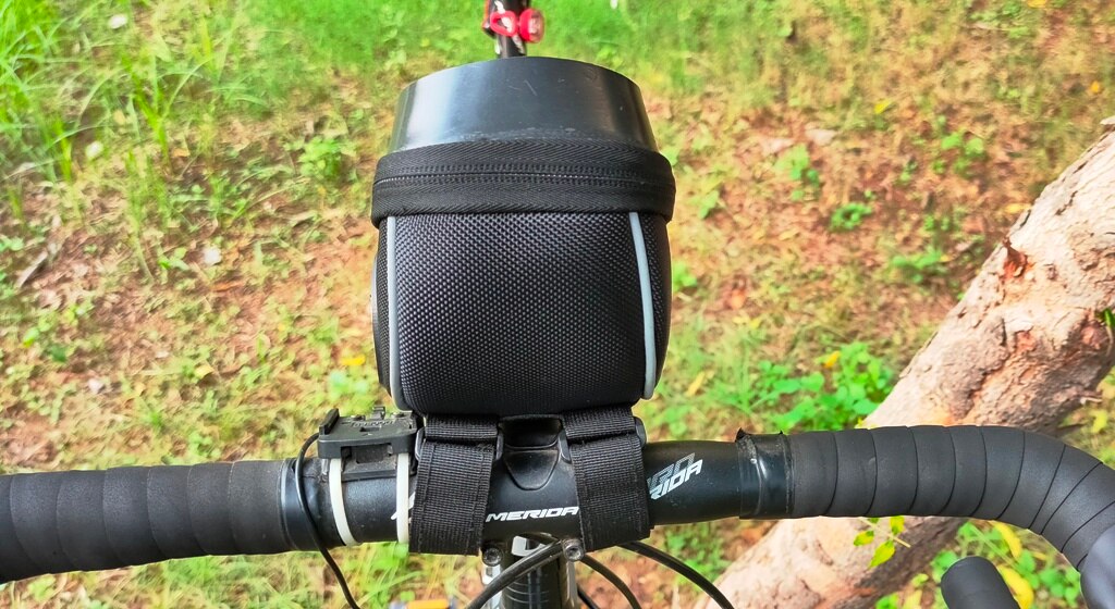 Cyclist using the touch-sensitive screen of a mobile phone inside the Trek N Ride Handlebar Bag during a ride.