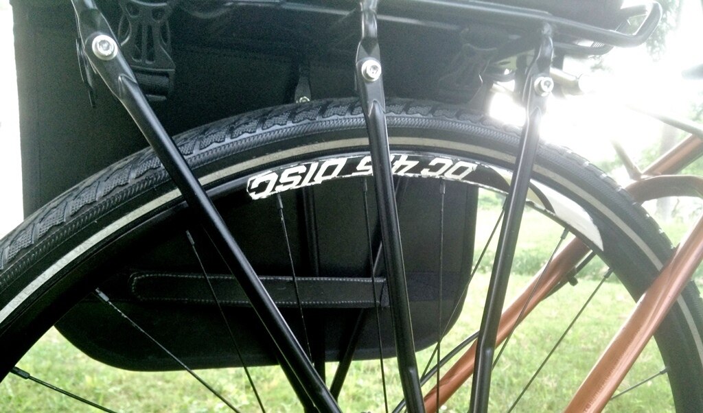 Side view of the Trek N Ride pannier showing adjustable straps for secure attachment.

