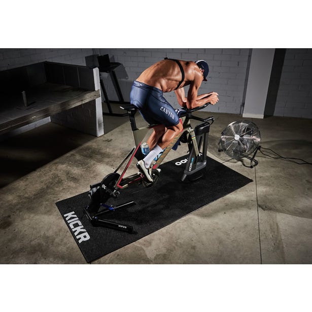 A Wahoo KICKR Trainer setup with the Wahoo KICKR Floormat, highlighting its noise-insulating and anti-vibration properties.