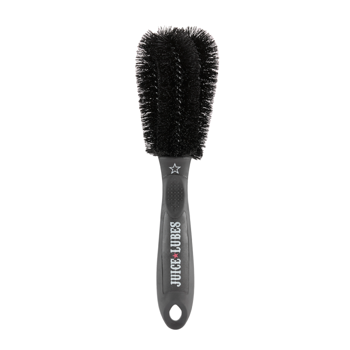 Close-up of Juice Lubes Double Ender brush, showing its two prongs and stiff bristles for effective grime removal from bike gears.


