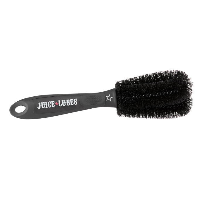 A Juice Lubes Double Ender brush, an essential tool with a two-pronged design for precision cleaning of bicycle cogs and derailleur pulleys.