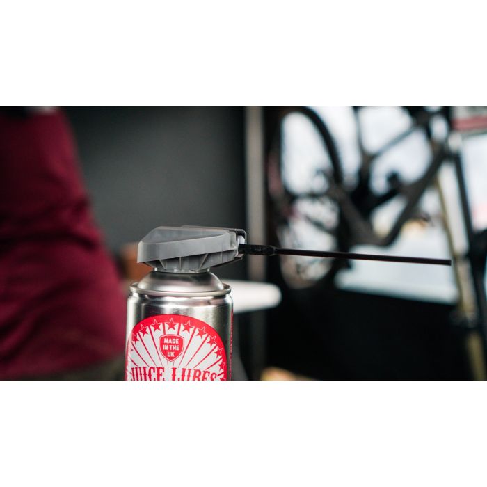 Juice Lubes JL69 Moisture & Protection Spray (400ml) on a bicycle chain, demonstrating its ability to lubricate and repel water.